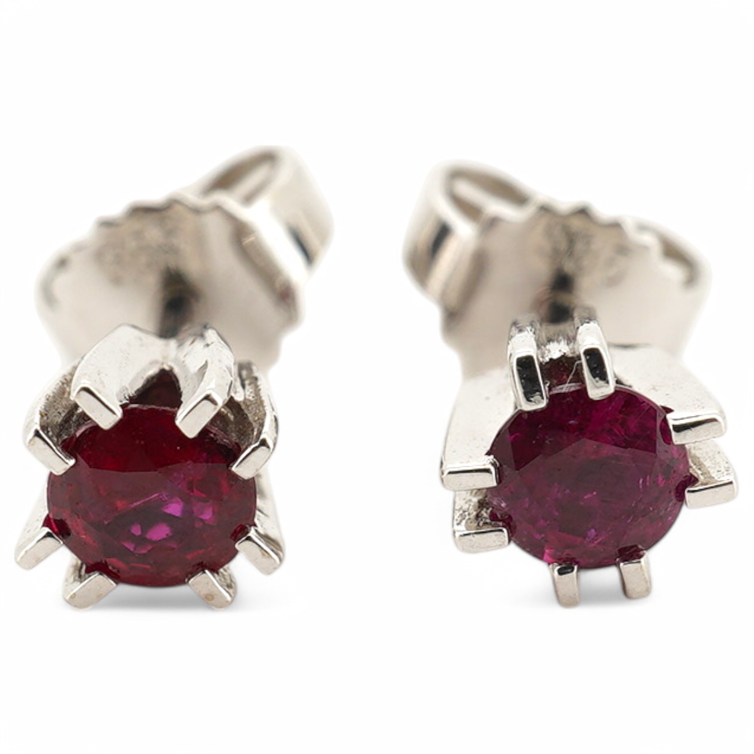 A modern pair of 585 white metal and solitaire ruby set ear studs, overall diameter 5mm, gross weight 1.4 grams. Condition - good